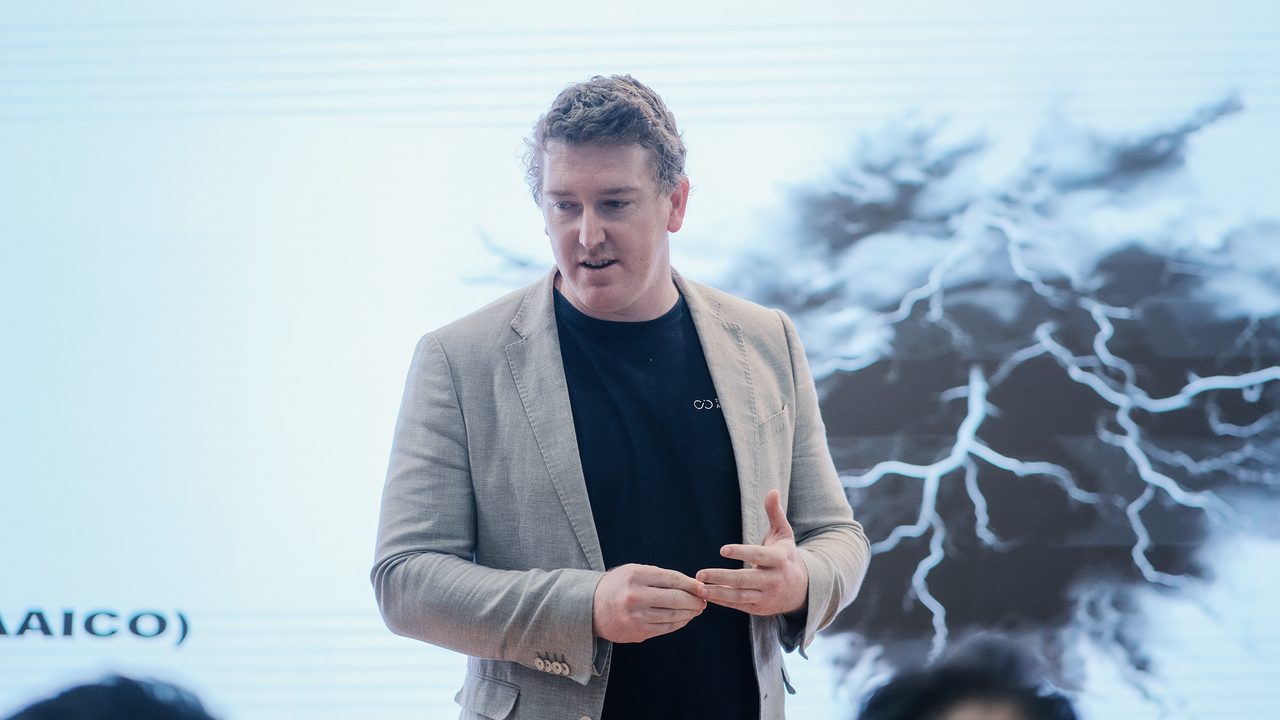 Phillip Kingston speaking at Decoding Data Science in Dubai, in front of a slide of a branching network.